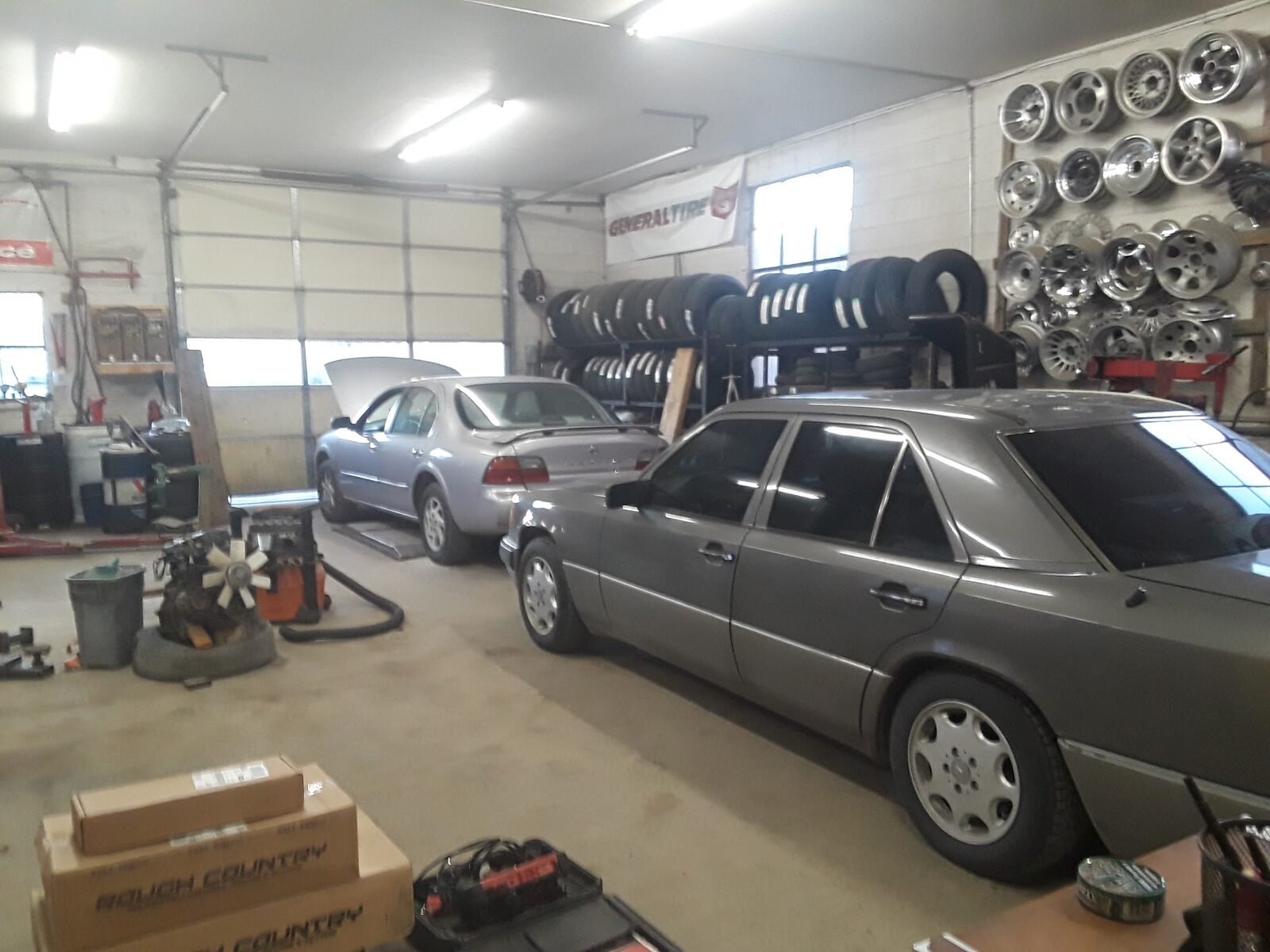 The service bay at Star Tire & Auto, cars on lifts and a wall of wheels