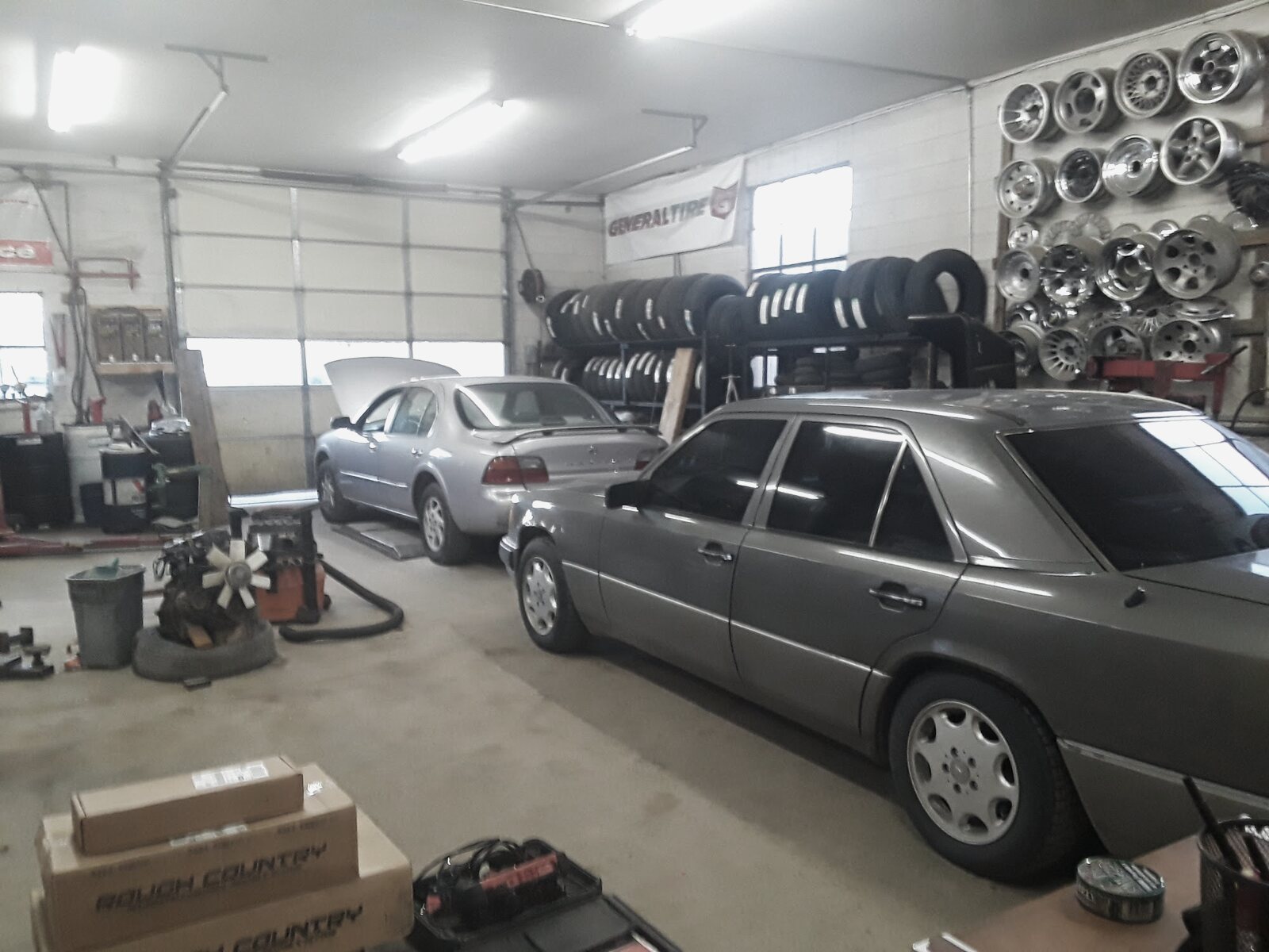 Inside the Star Tire service bay, cars on lifts and a wall of wheels